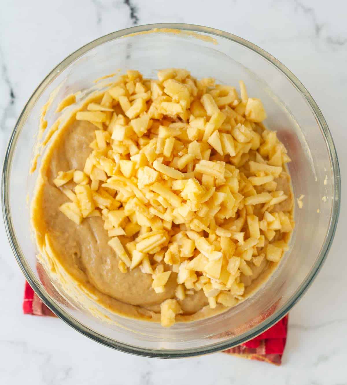 Diced apples on top of muffin batter.