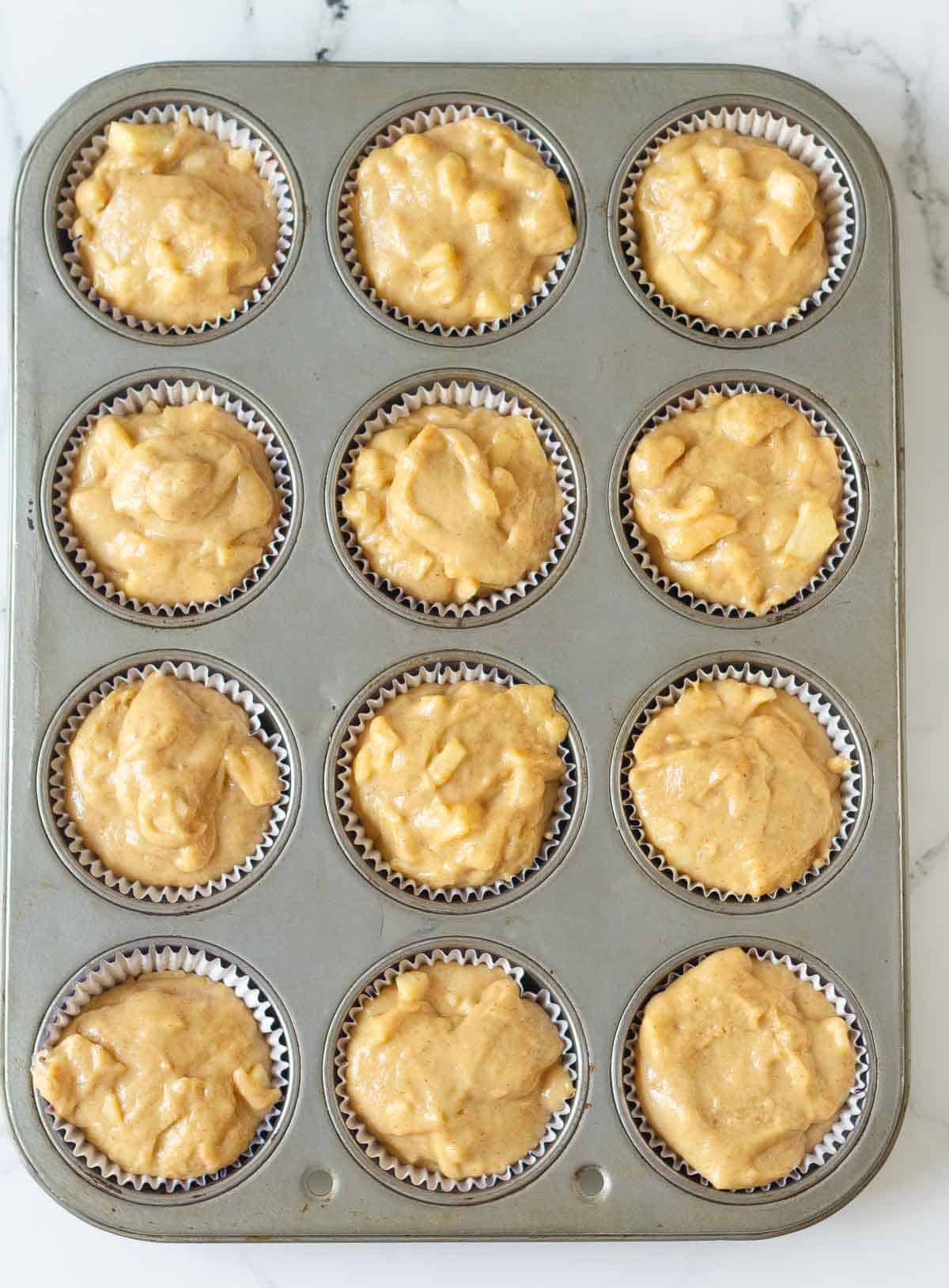 Muffin batter in a muffin tray.