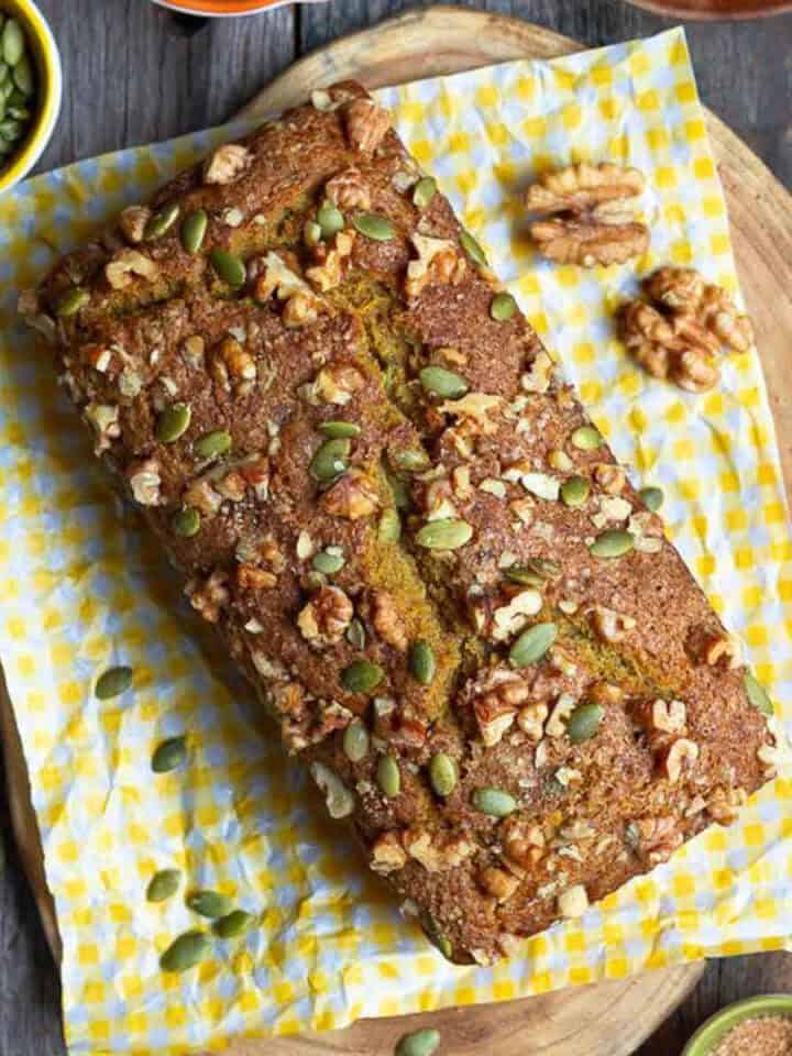 Pumpkin bread on a yellow napkin on a wooden board.