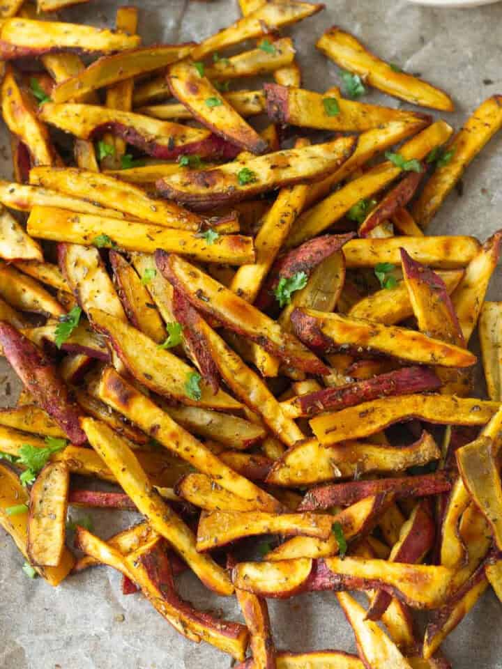 Baked sweet potato slices on parchment paper.