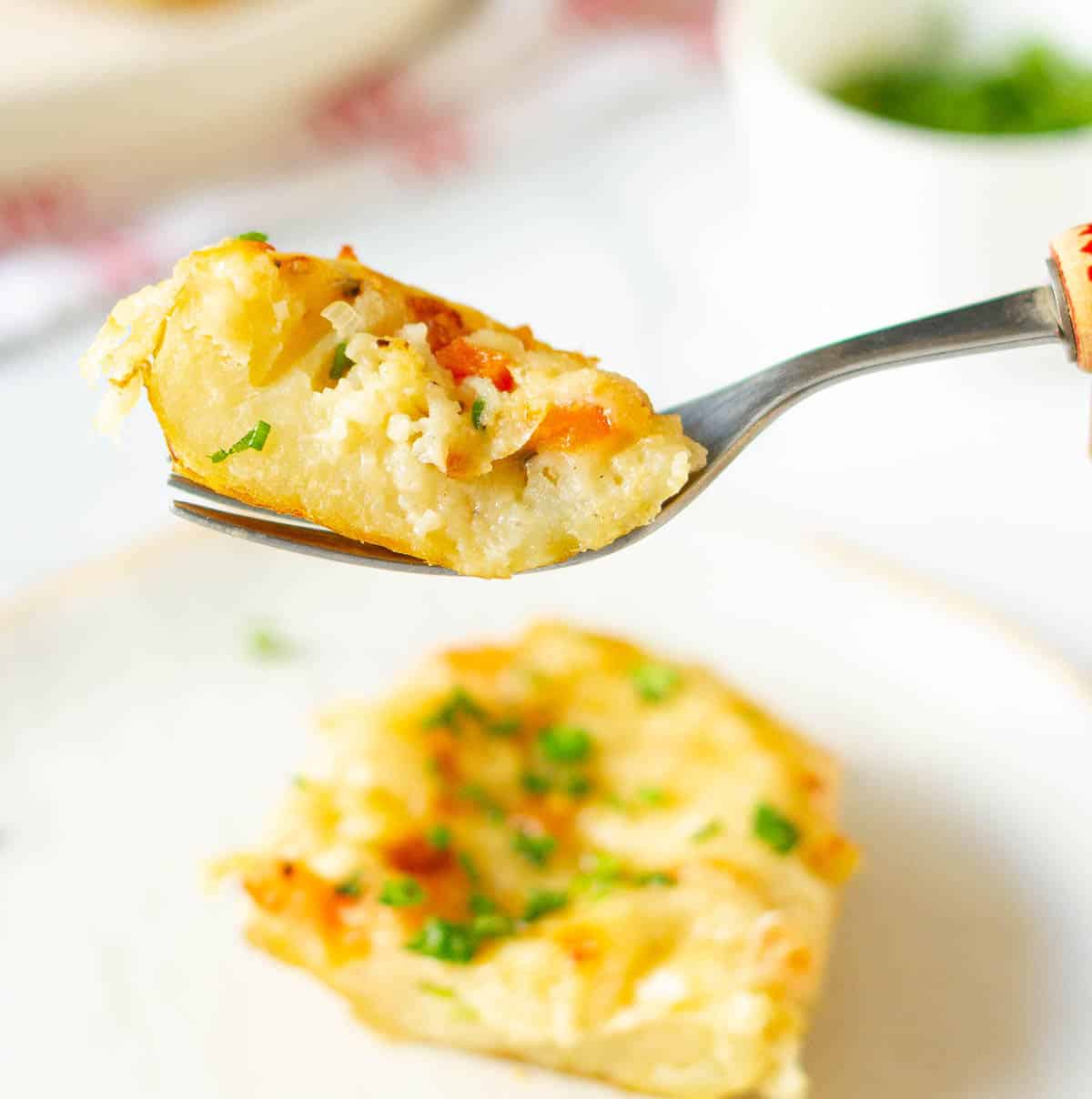 A bite of baked potato on a fork.