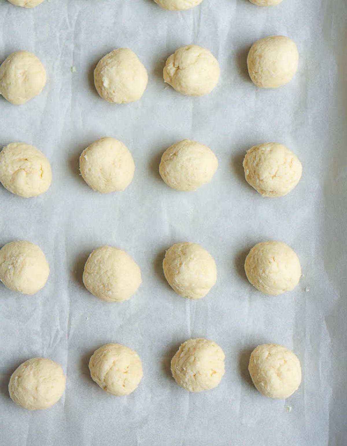 cookie dough balls on a parchment-lined baking tray.