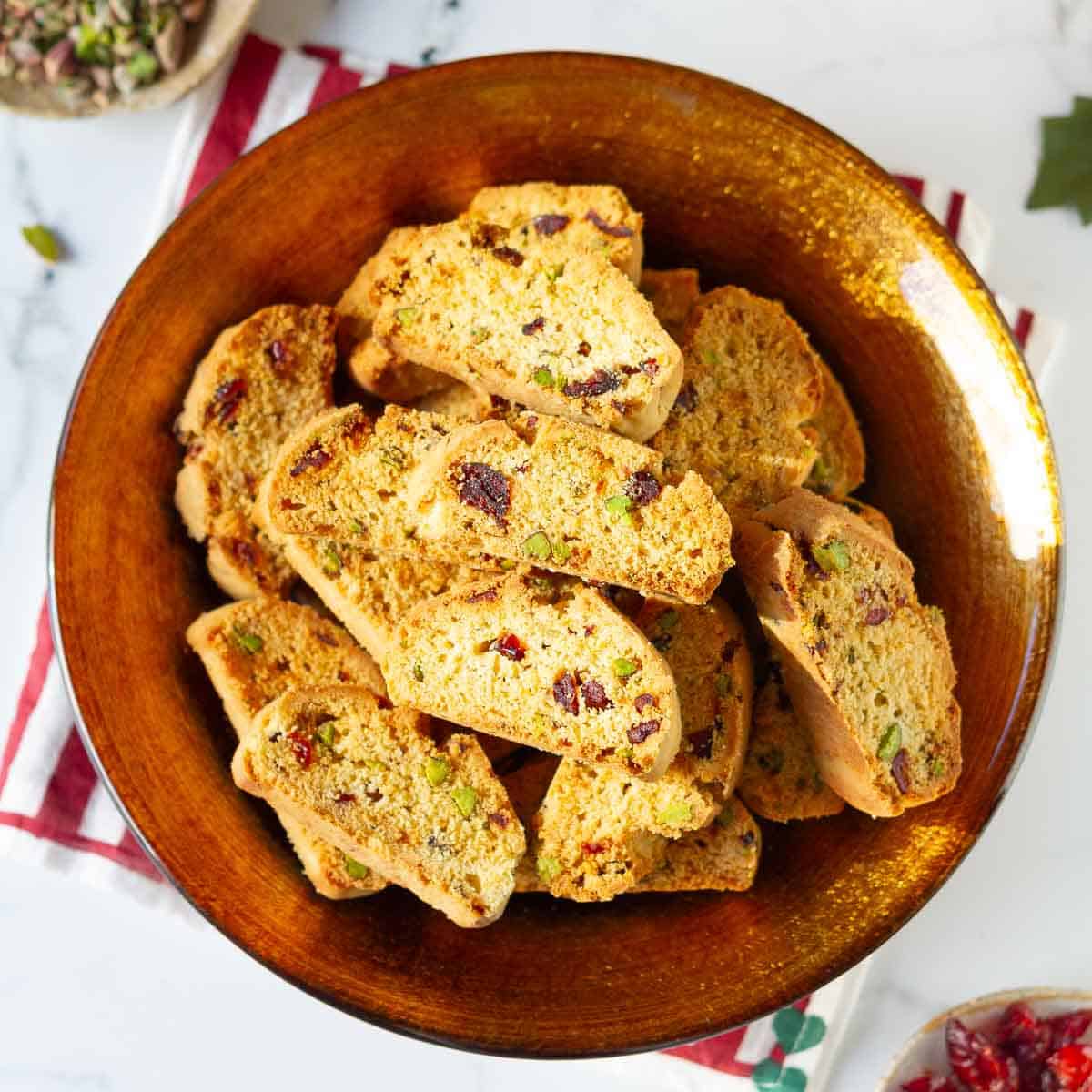 cranberry pistachio biscotti in a golden serving bowl.