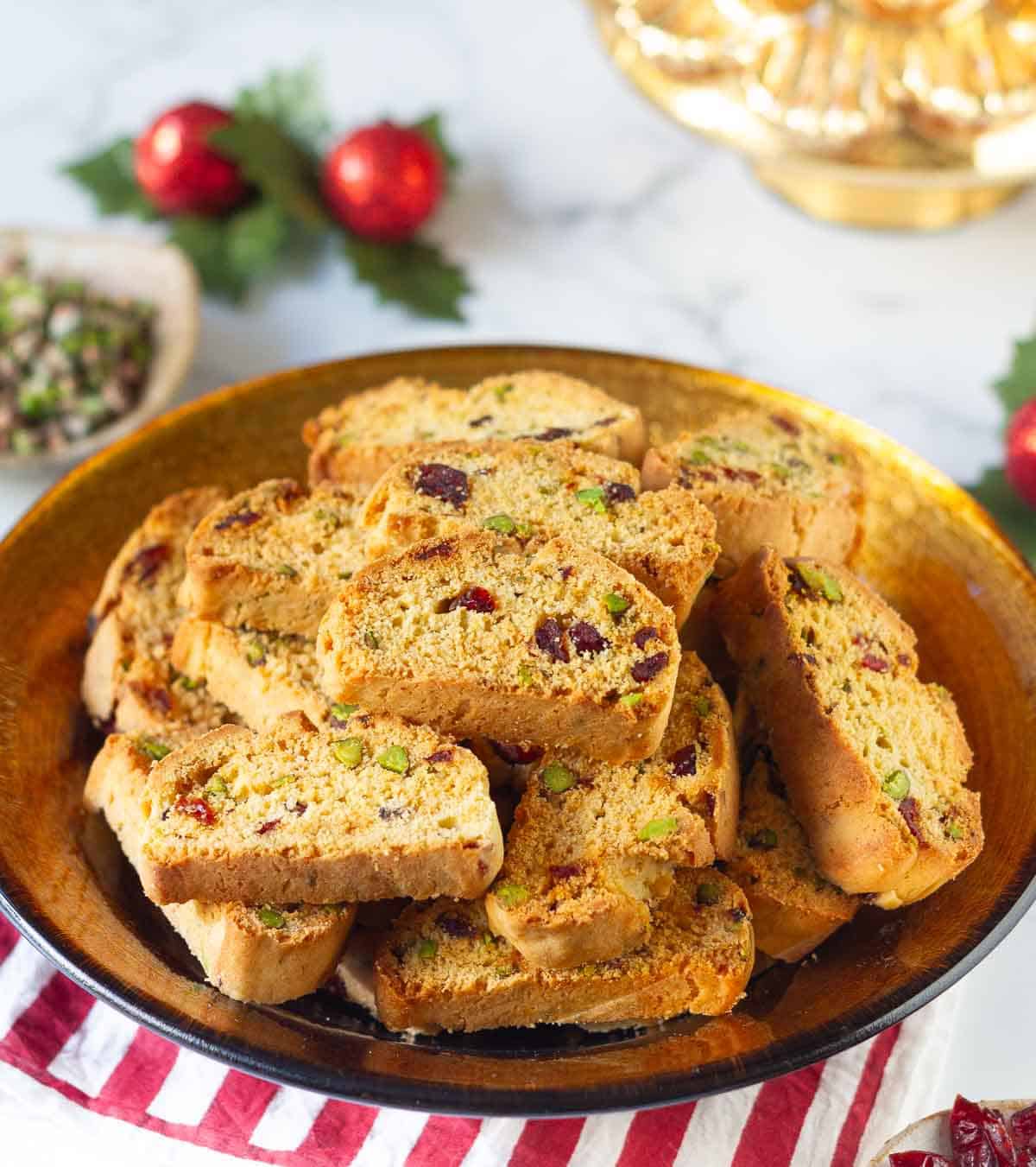 biscotti in a serving bowl with Christmas decorations in the background.