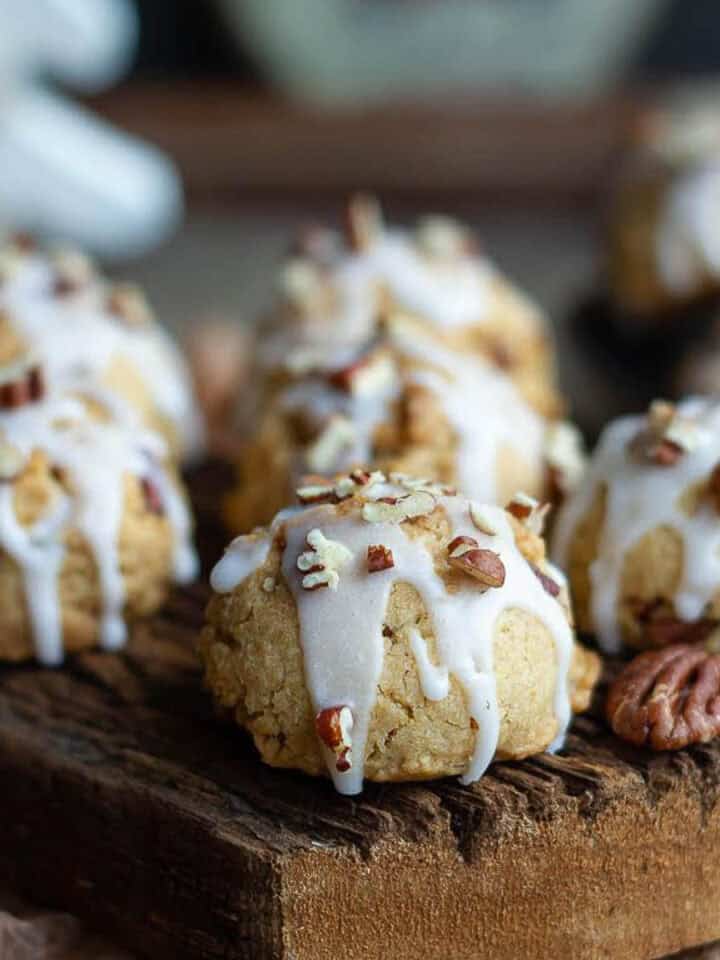 Maple pecan cookies with glaze on a wooden board.