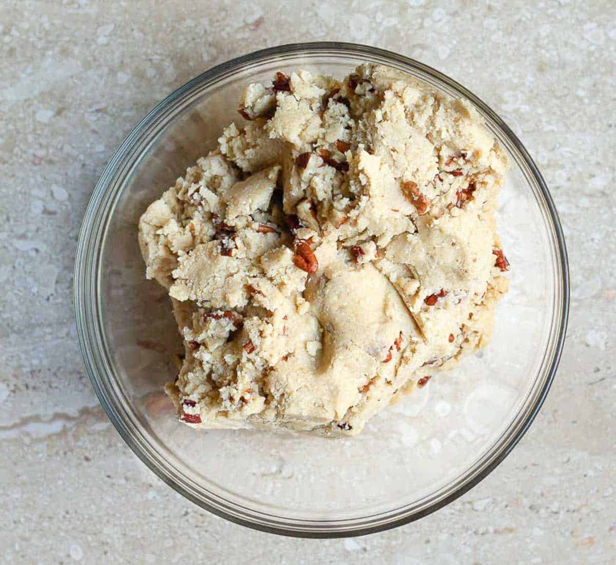 cookie dough with pecans in a mixing bowl.