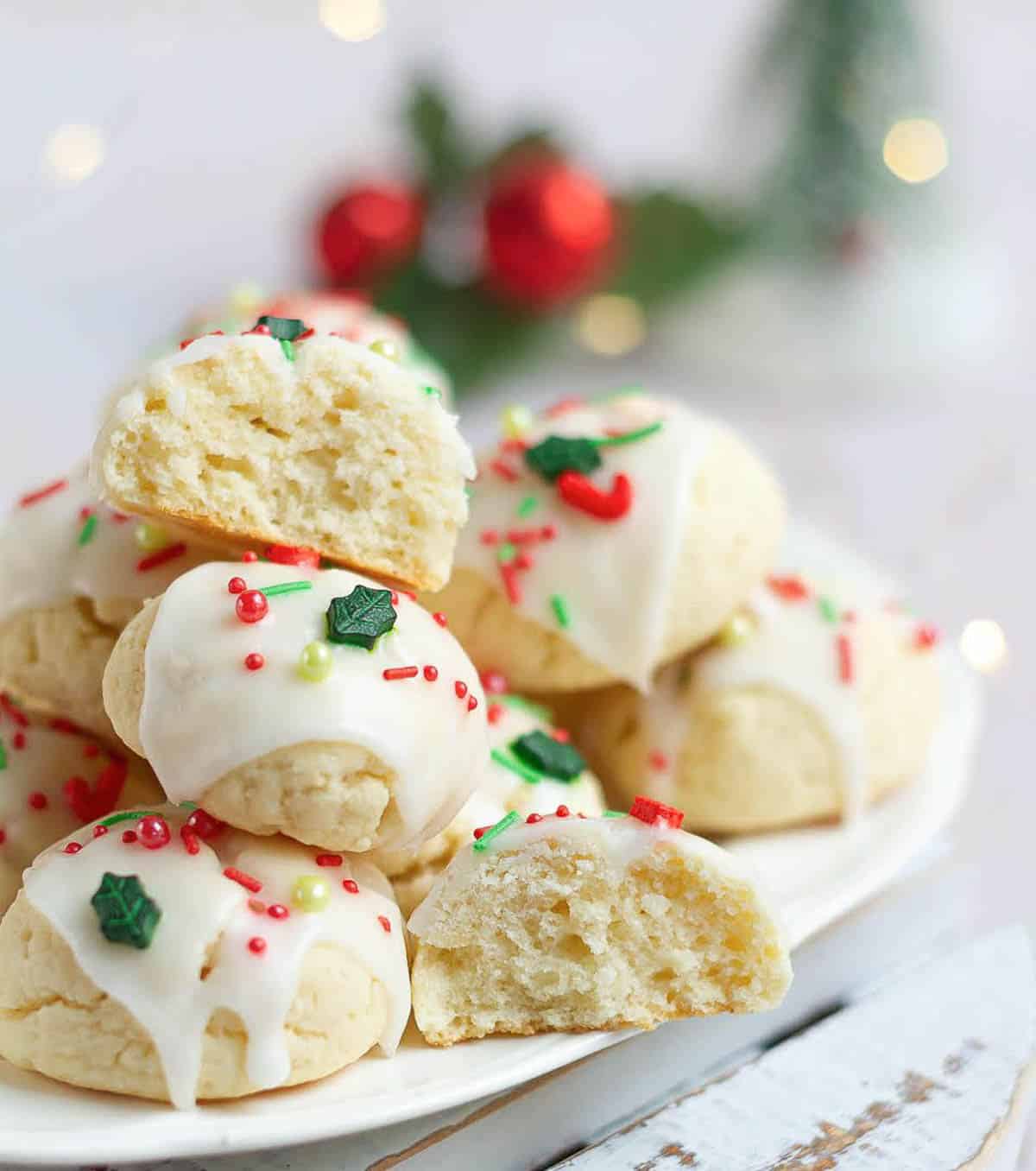 almond cookies on a platter with 2 halves of a cookie to show the soft texture.