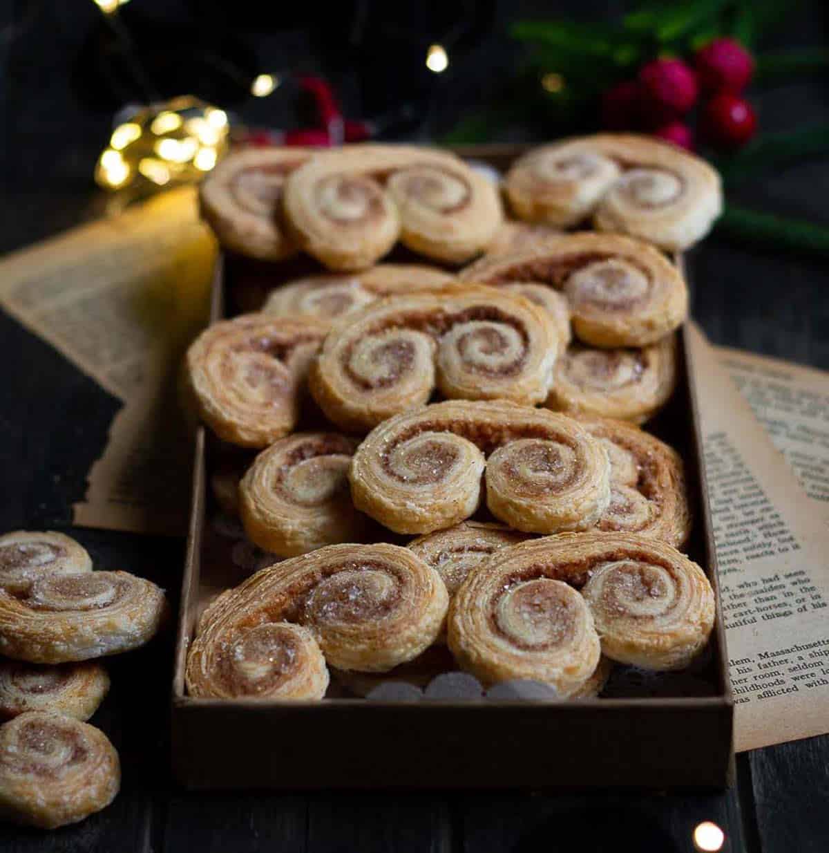 Cookies on a tray with lights and Christmas decor around.