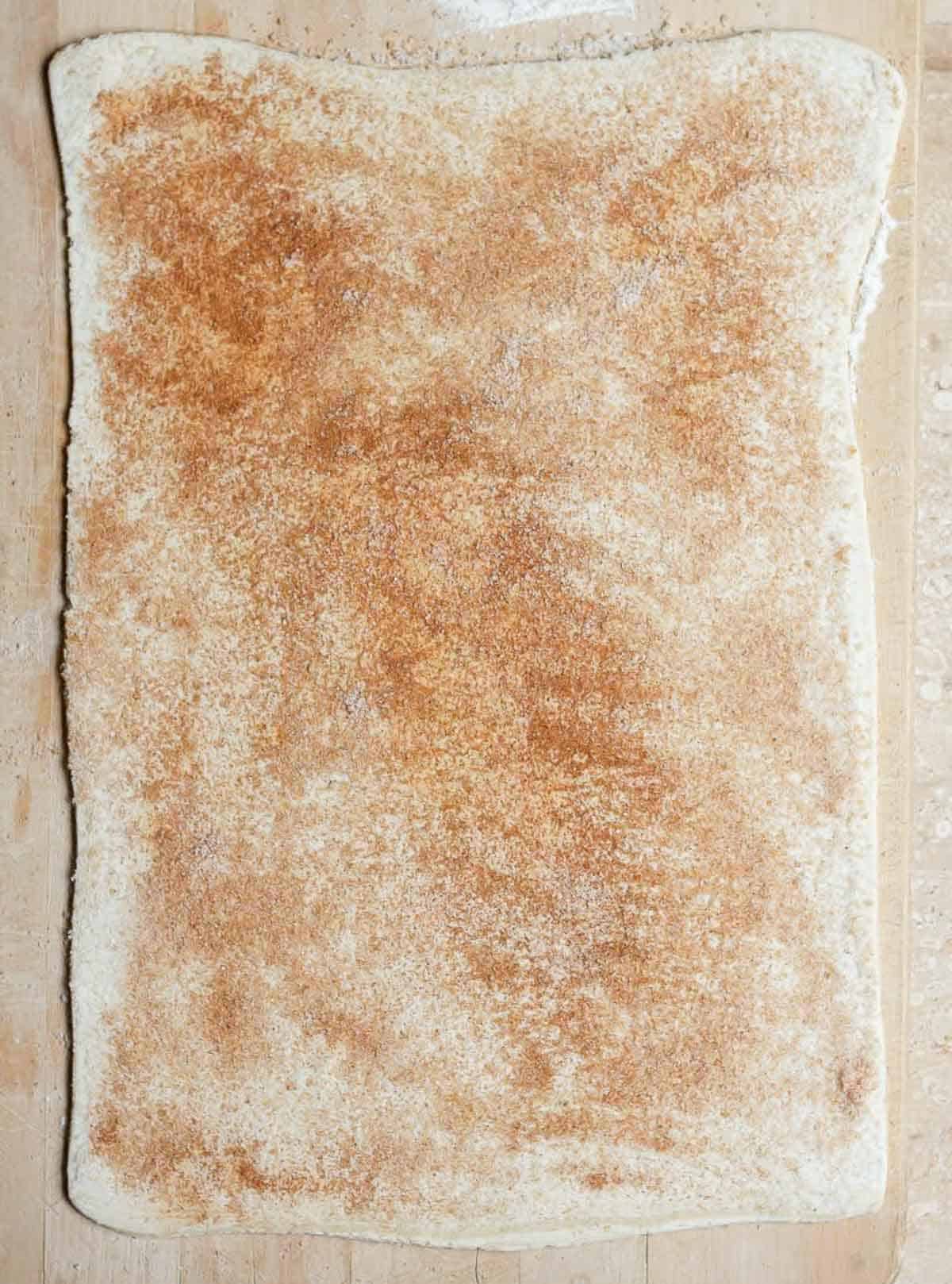 Puff pastry dough rolled out and sprinkled with sugar and cinnamon.