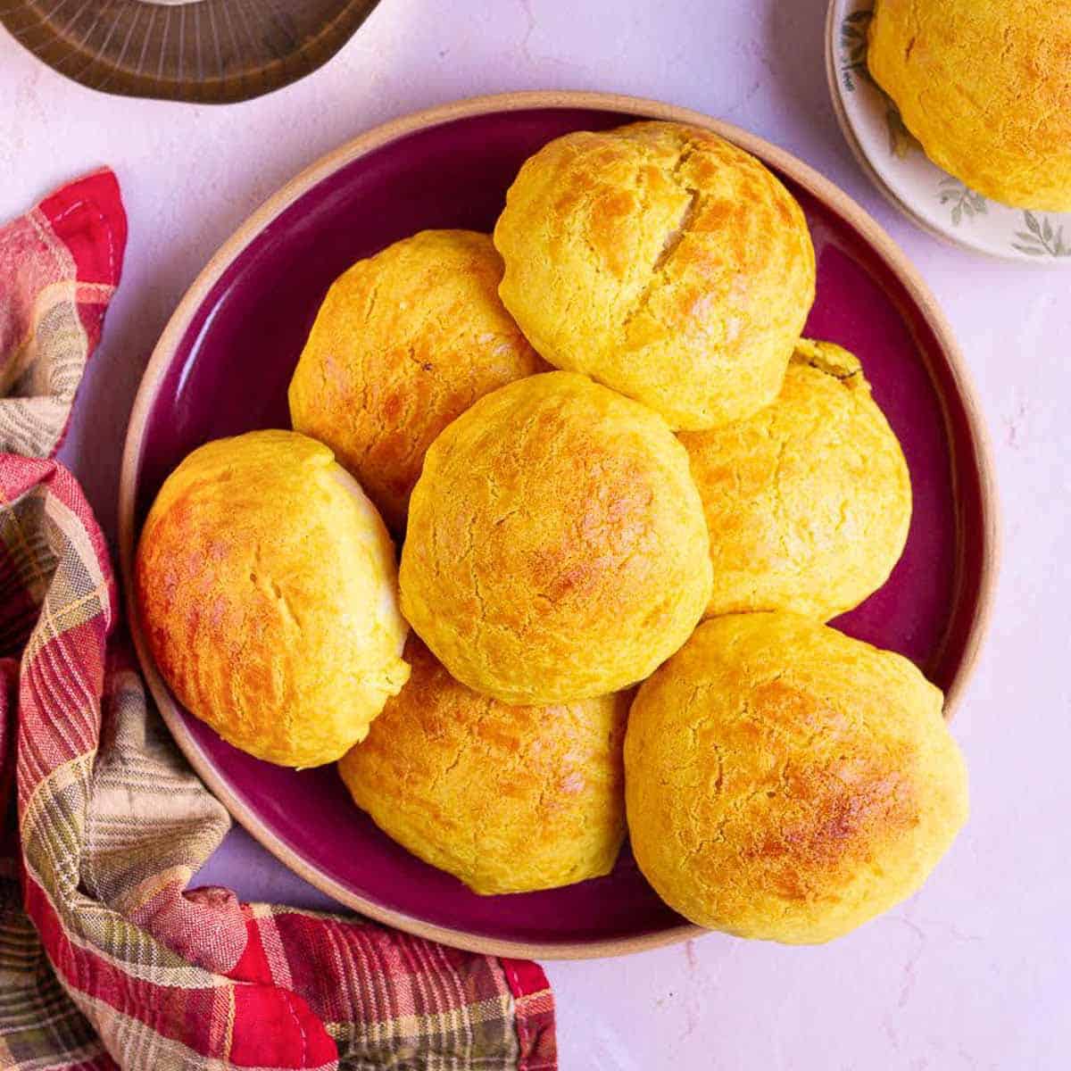 A red platter stacked with pineapple buns.