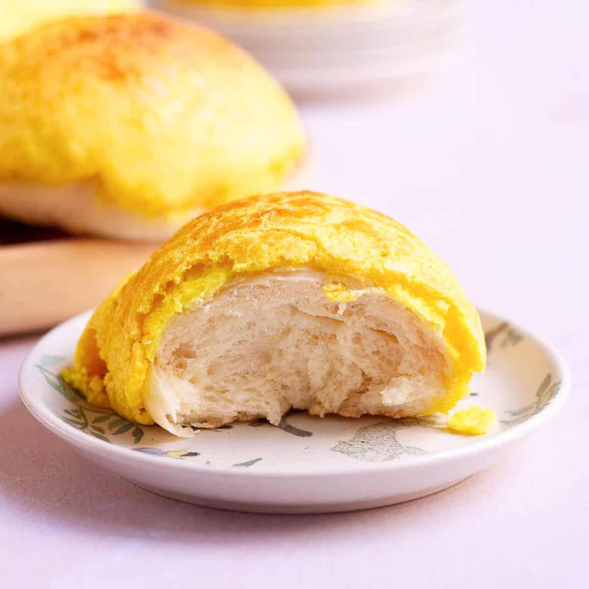 Half a bun on a small plate to show the fluffy interior.