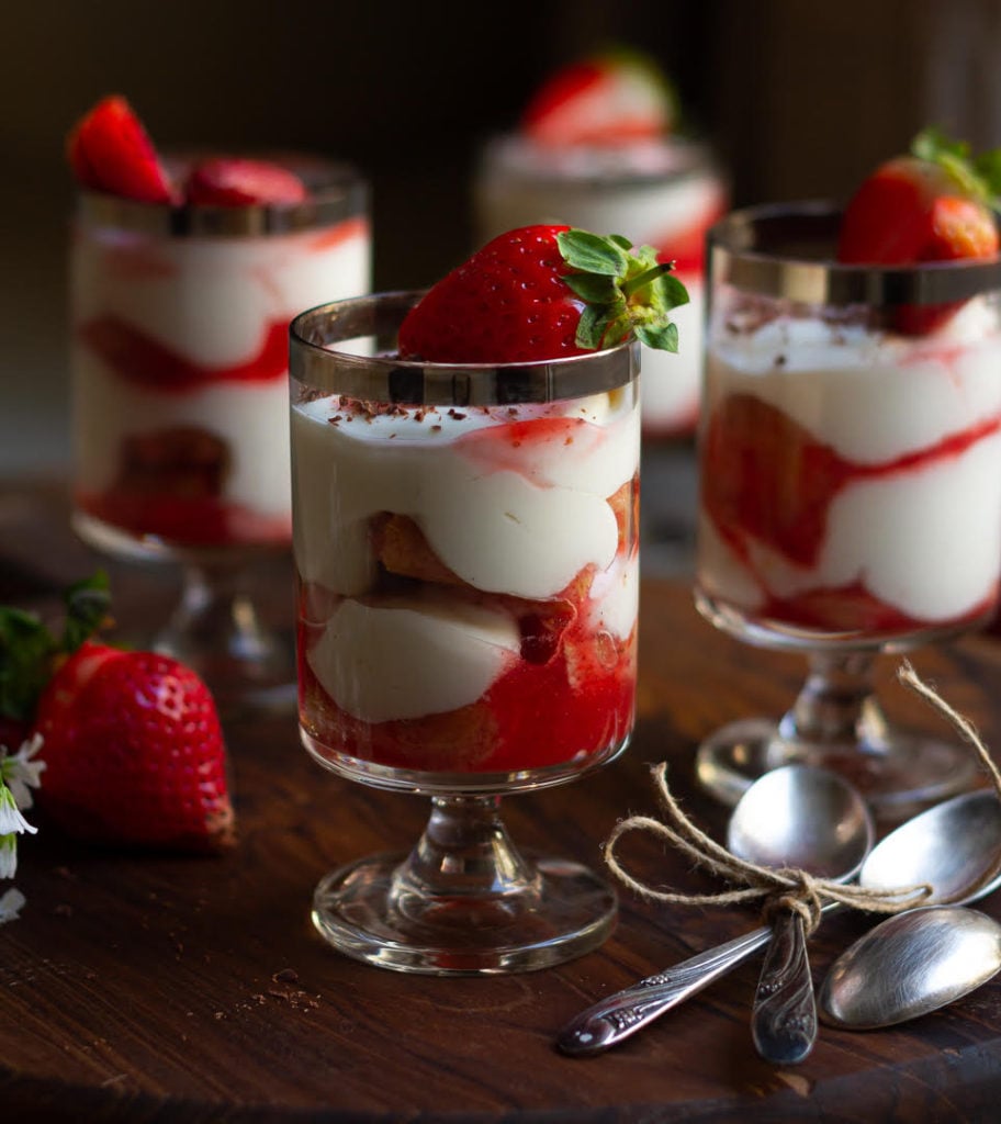 Strawberry Tiramisu served in 4 dessert glasses topped with fresh strawberries.
