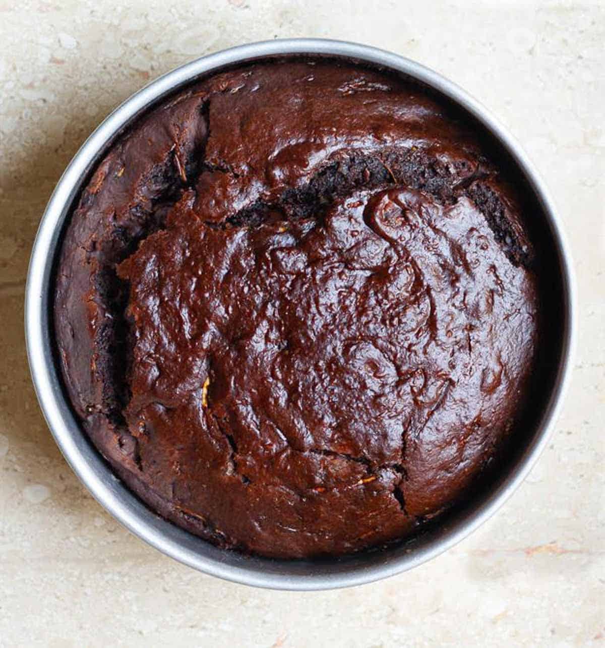baked chocolate zucchini cake in a round cake pan.