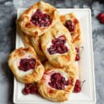 cherry puff pastry tarts on a white platter.