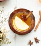 Toddy in a glass with cinnamon and apple slices.