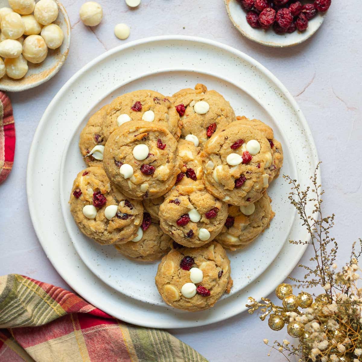 White Chocolate Cranberry Cookies on a platter with ingredients around.