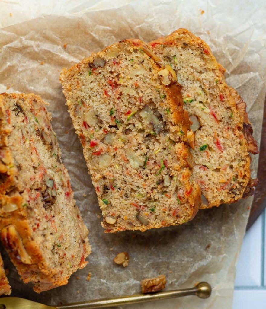 Slices of carrot zucchini bread on parchment paper.