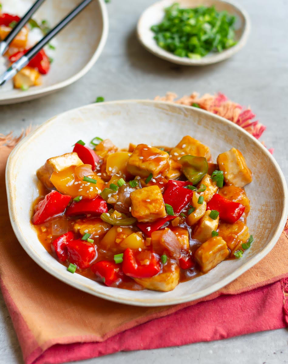 Crispy Tofu With Sweet and Sour Sauce garnished with spring onions and sesame seeds