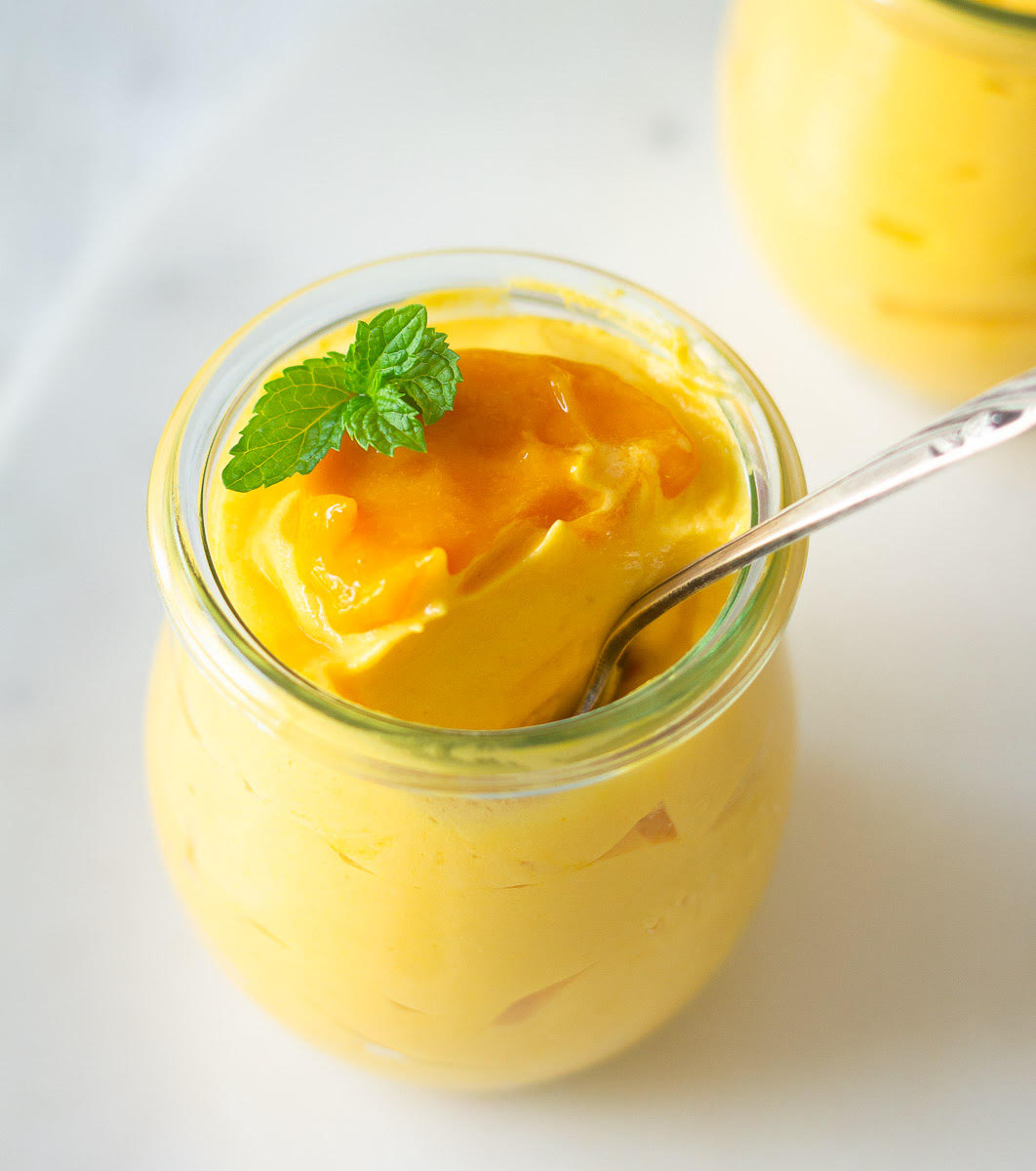 Mango mousse in a serving jar with a spoon
