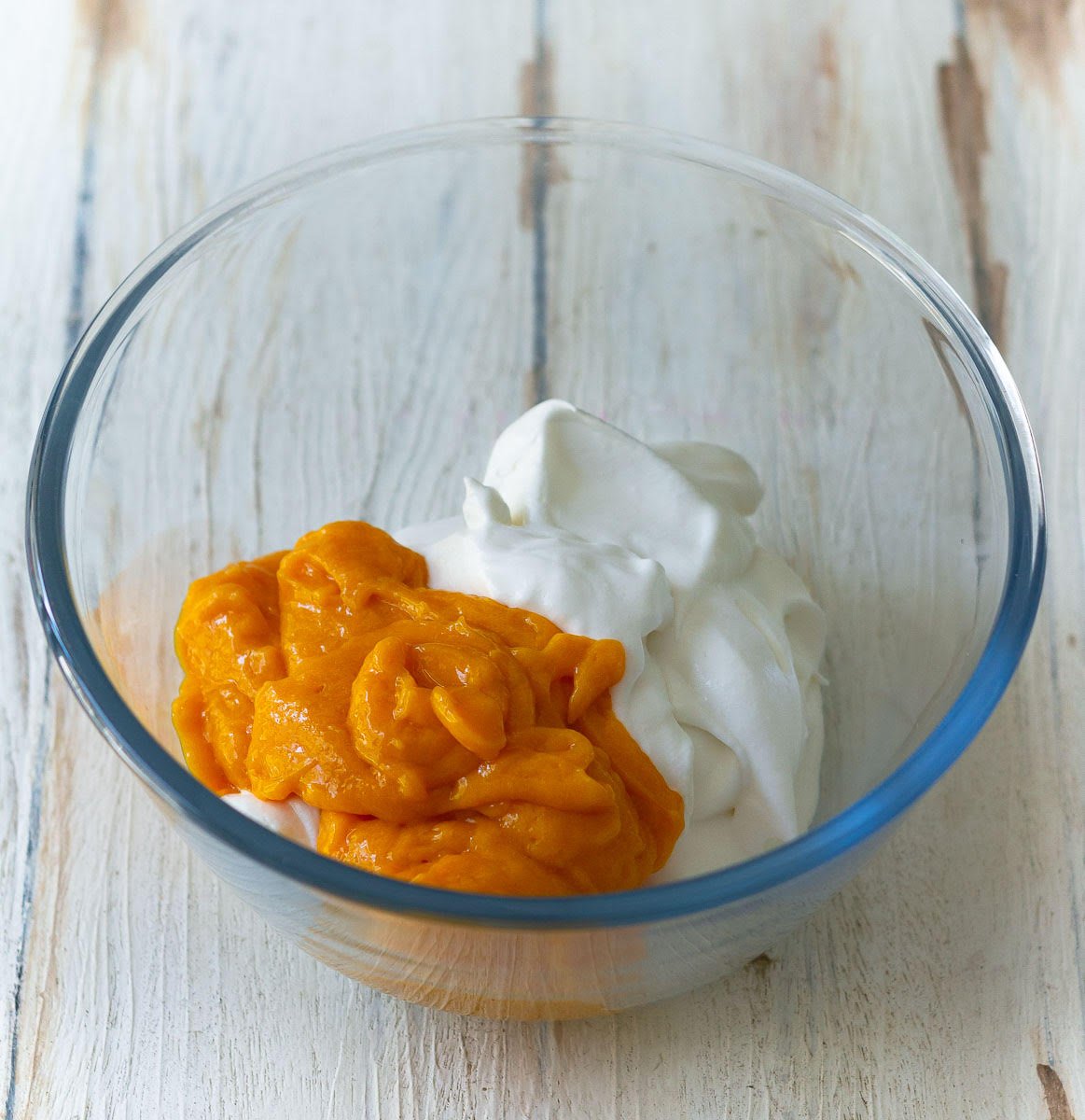 Folding the mango puree into the whipped cream