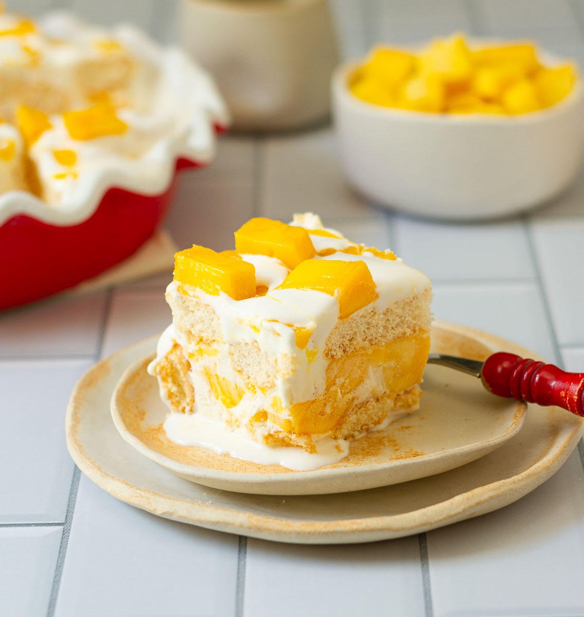 Mango Float slice on a plate with a fork.