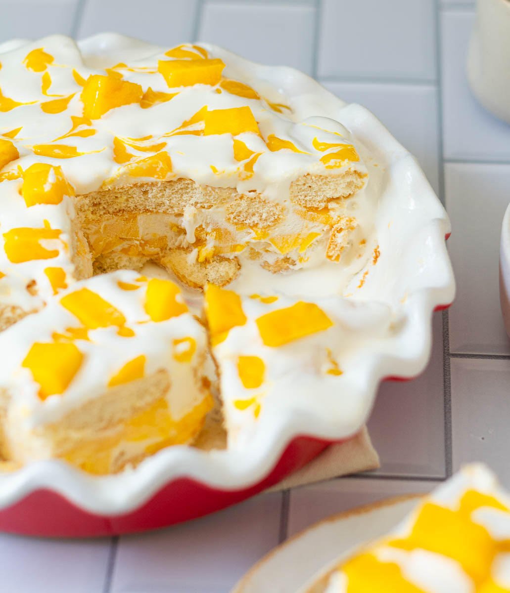 Mango float dessert with a slice taken out to show the cross-section.