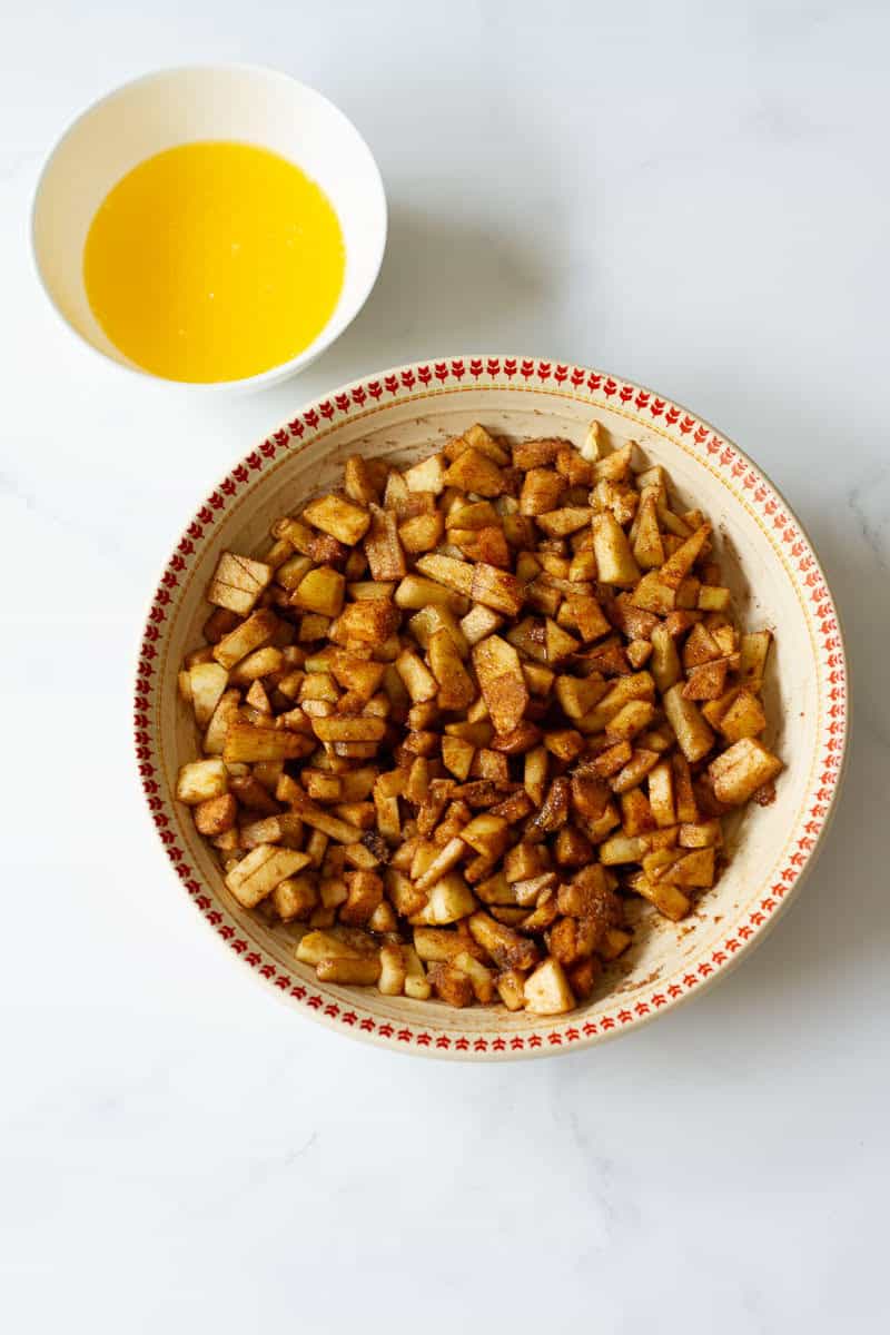 apples mixed with brown sugar and cinnamon powder. Melted butter in a small bowl