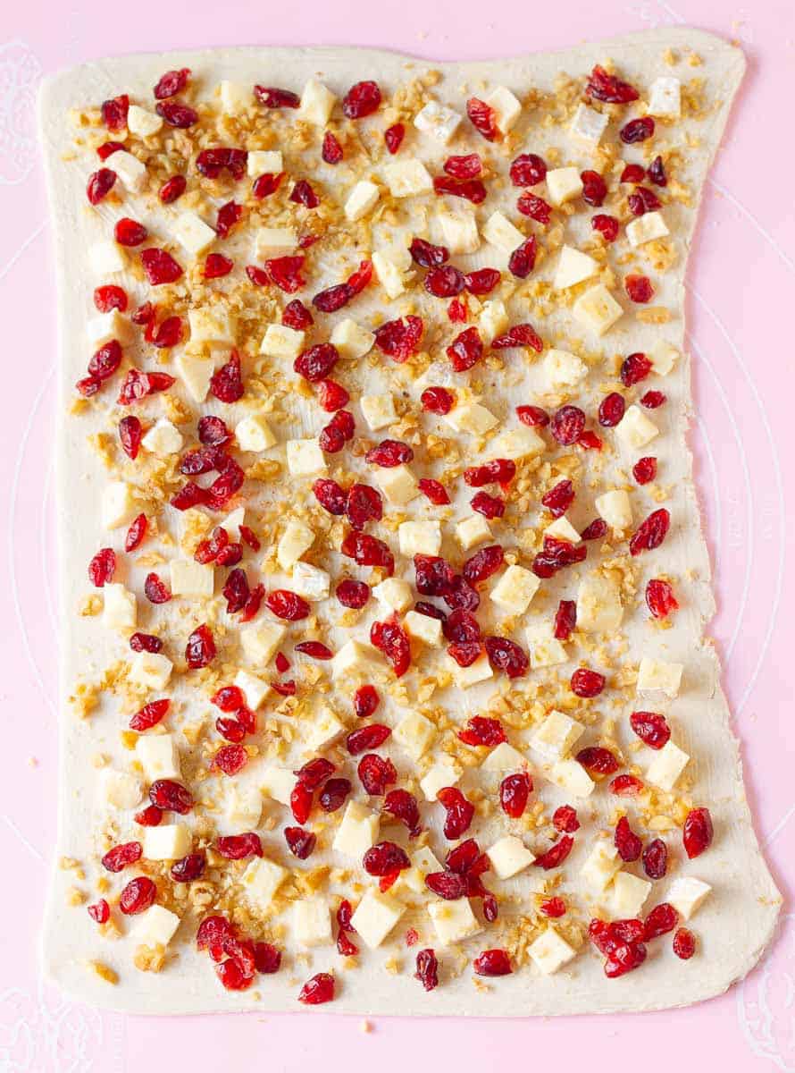 cranberries, cheese and walnuts sprinkle on top of rolled out pastry.