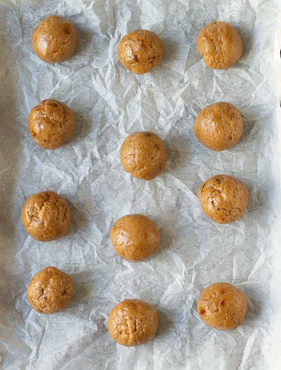 cookie dough balls on a parchment lined baking tray