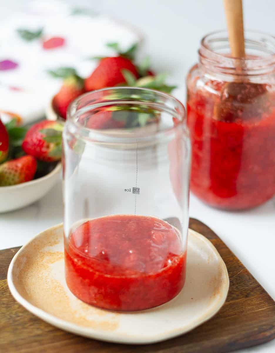 a few spoonfuls of strawberry syrup in glass