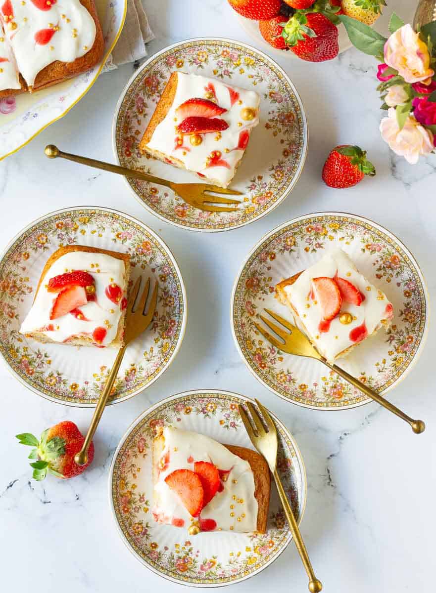Fresh Strawberry Poke Cake pieces on small plates
