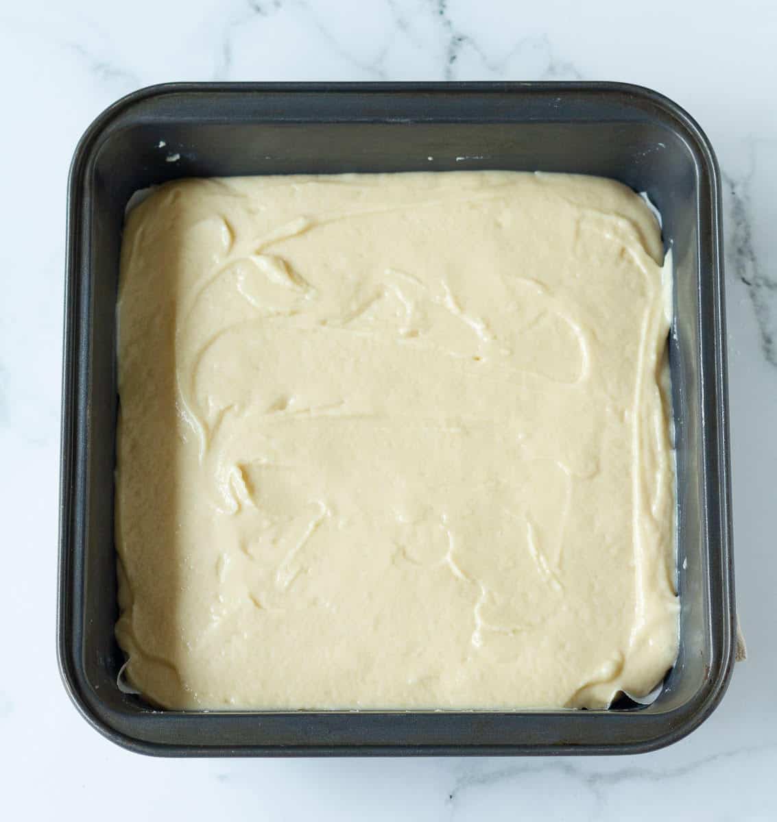 cake batter in a square baking tin.