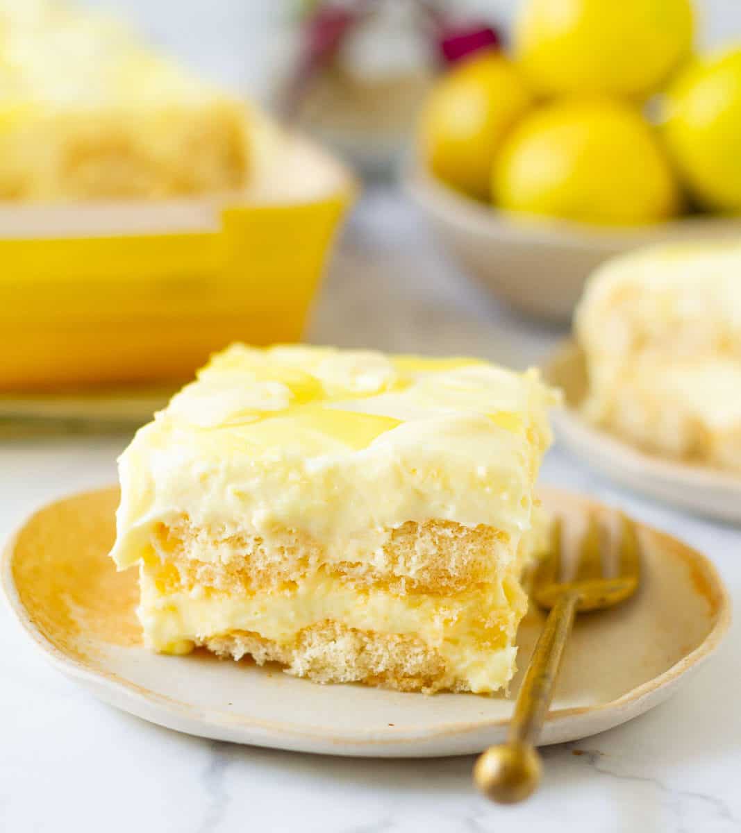 a slice of lemon tiramisu on a small plate with a fork