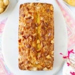Mango bread on a white marble board with ingredients on the side.