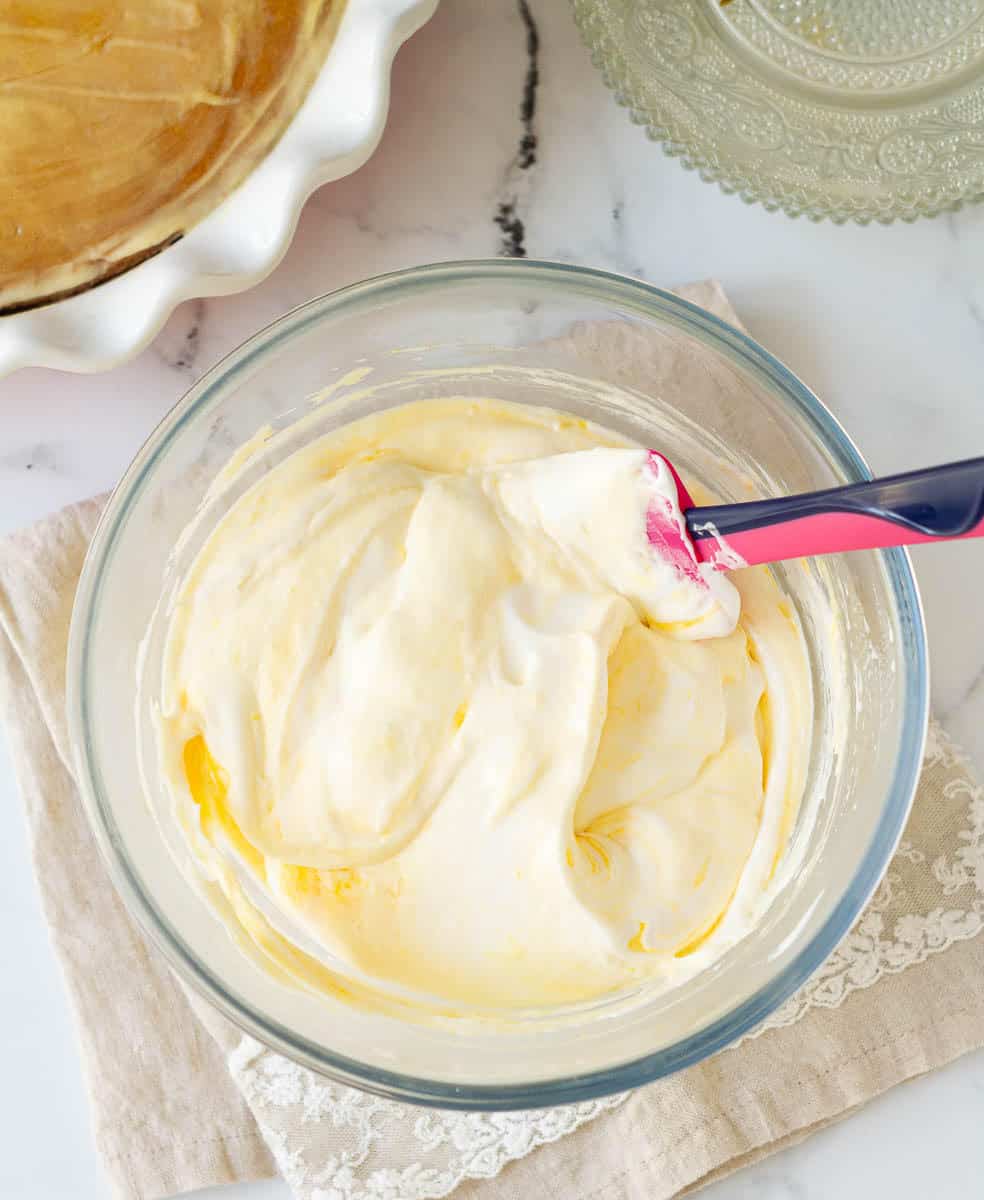 Mango Whipped Cream for mango tres leches in a bowl.