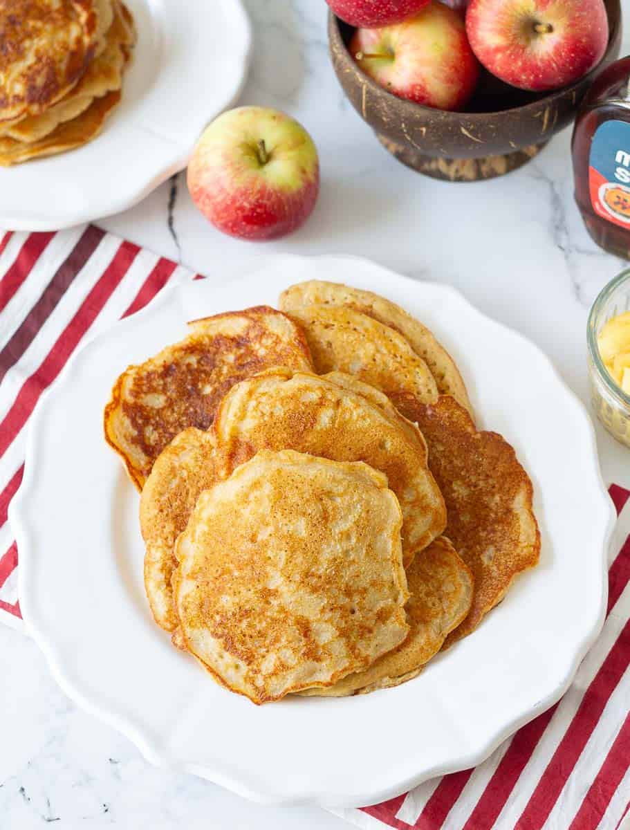 a bunch of apple pancakes on a plate with ingredients in the background.