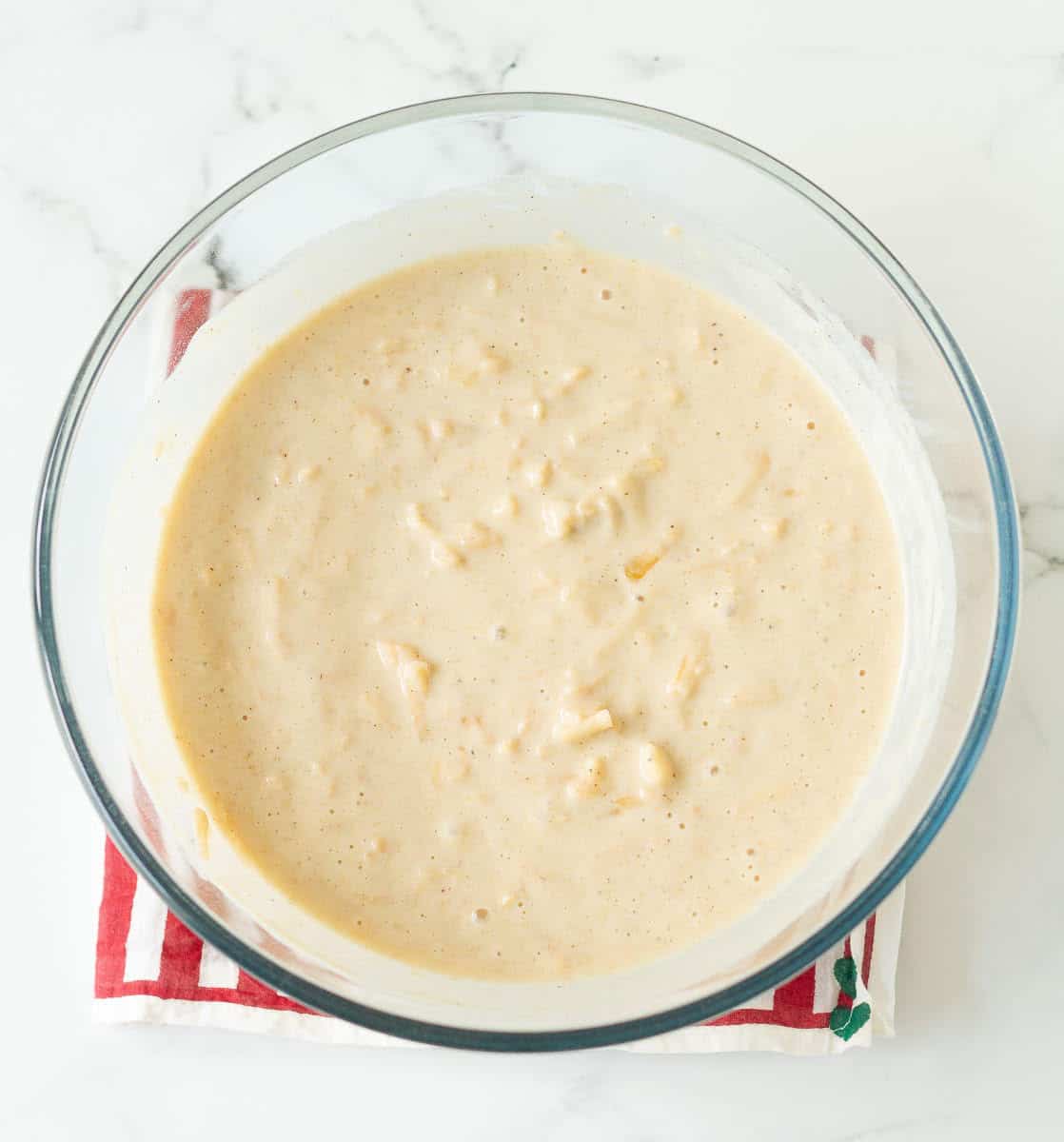 Apple pancake batter in a glass bowl.