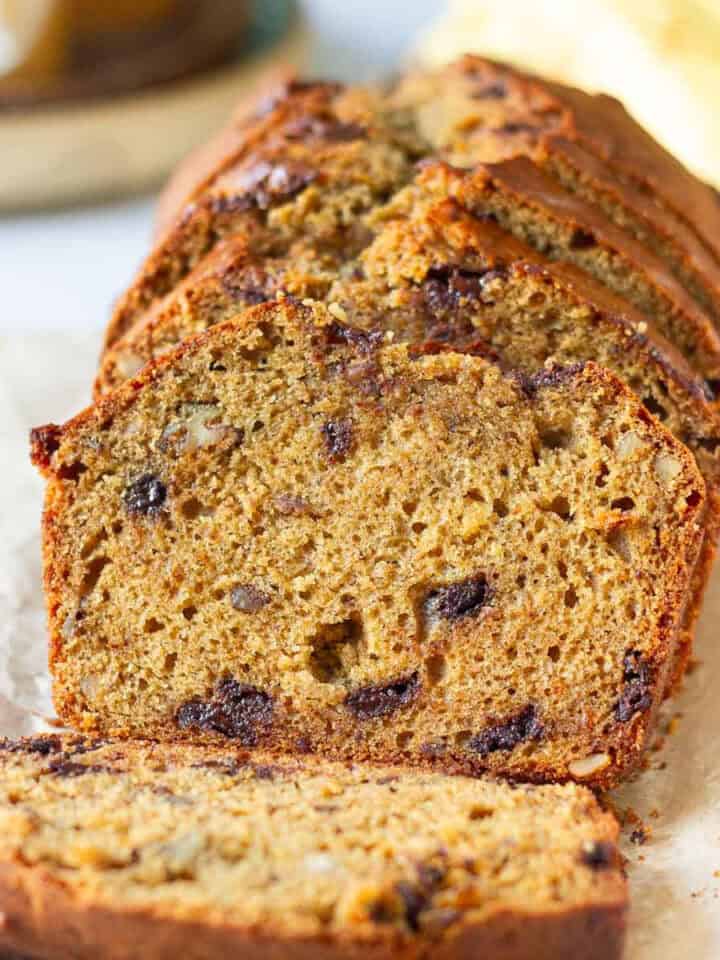 sliced sourdough banana bread with ingredients in the background.