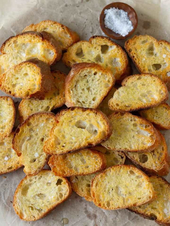 Toasted bread slices on a piece of parchment paper.