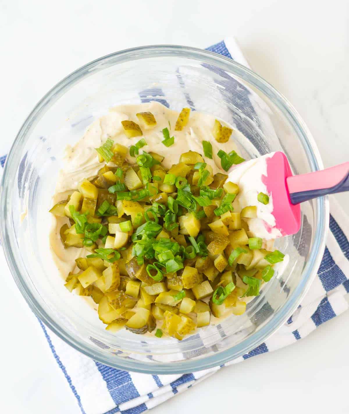 Chopped pickles and green onions on the cream mixture.