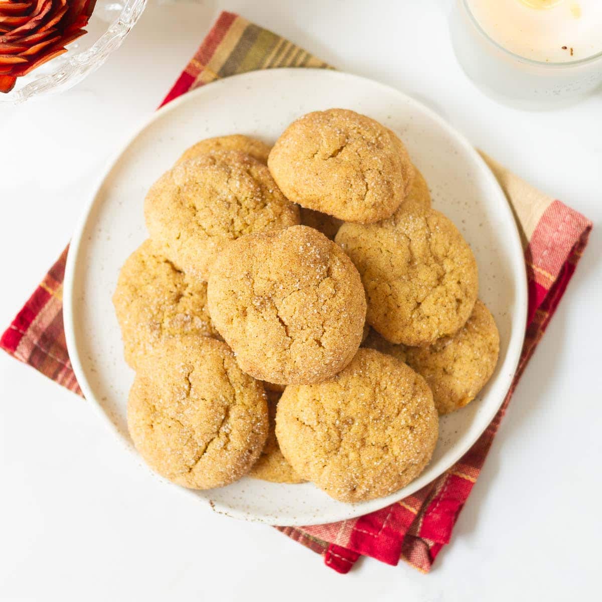 pumpkin snickerdoodle cookies stacked up on a plate.