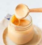Wooden spoon in a jar of sauce.