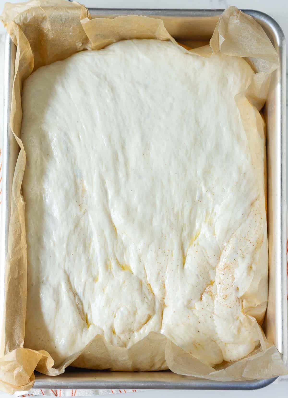 Proofed bread dough on parchment paper.
