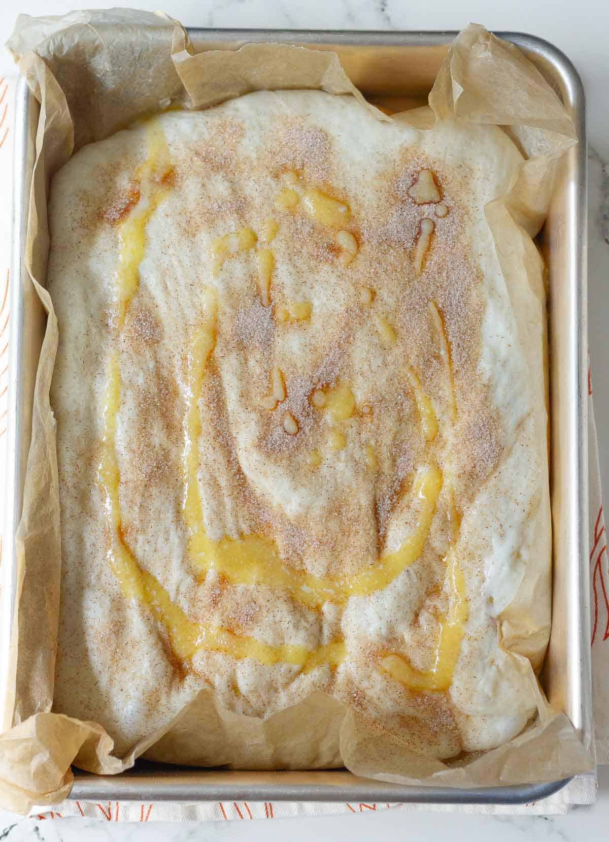 Bread dough topped with cinnamon sugar and melted butter.