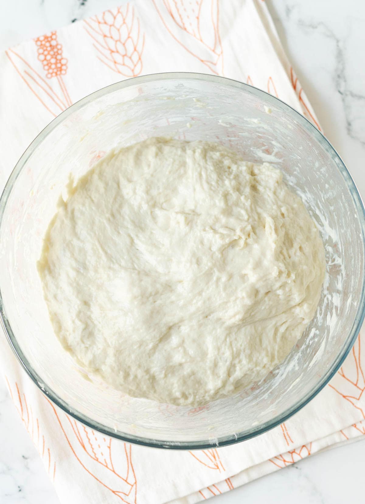 Deflated bread dough in a mixing bowl.