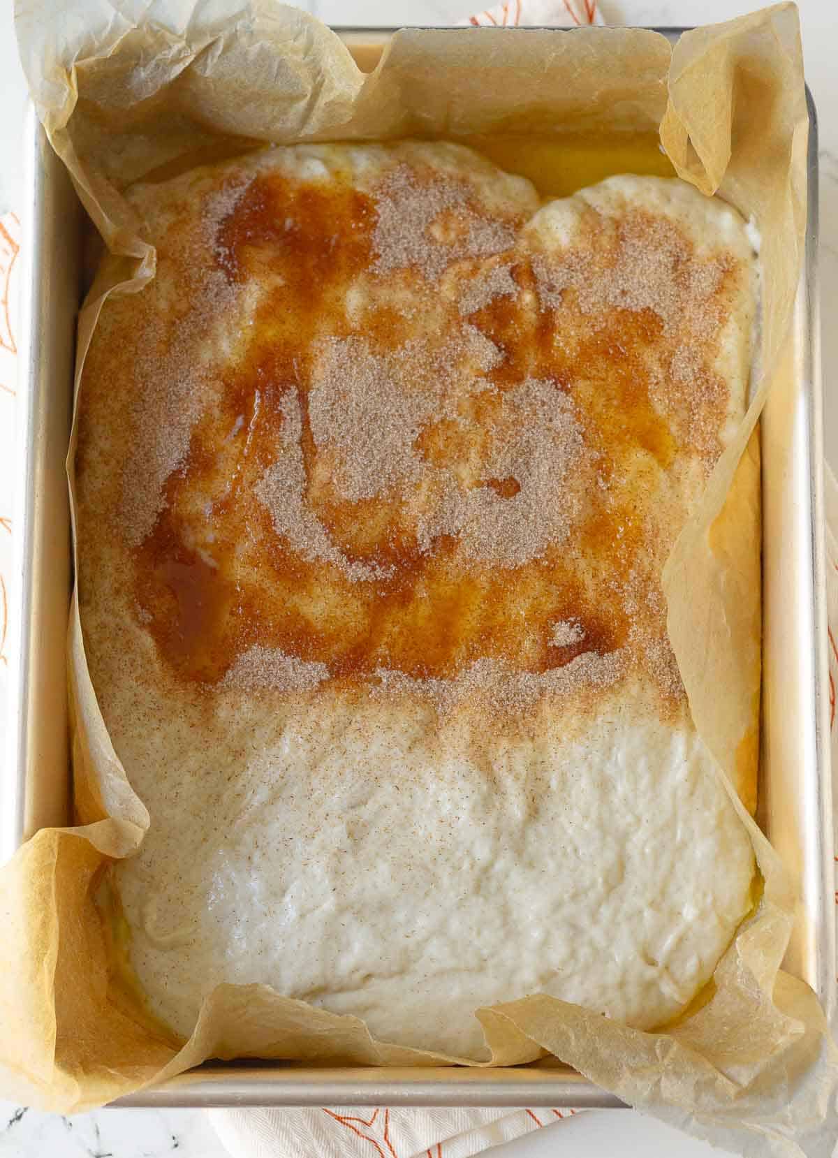 Cinnamon sugar and melted butter on one half of the bread dough.