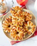 Puff pastry apple donuts on a plate with ingredients around.