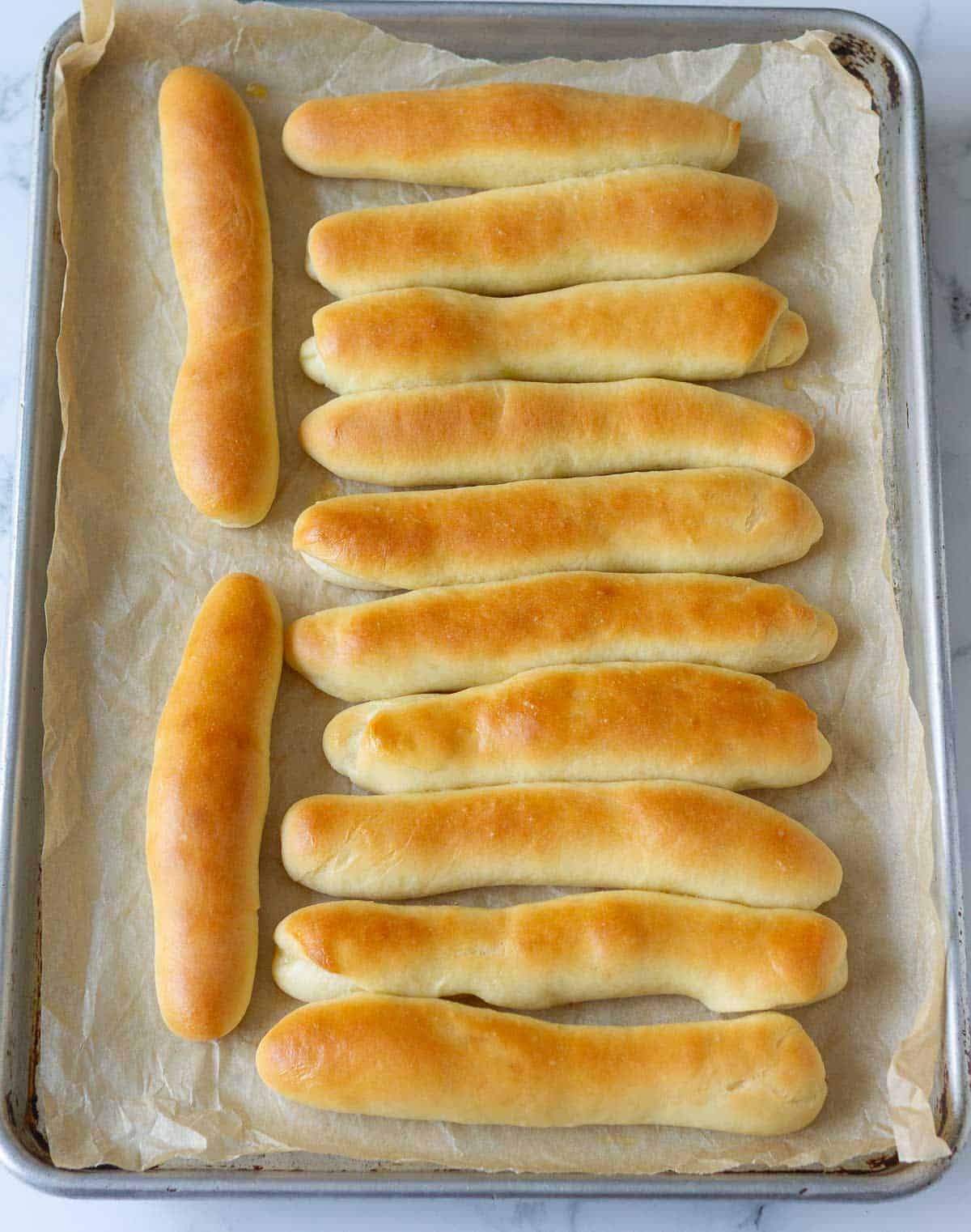 Baked bread sticks on a baking tray.