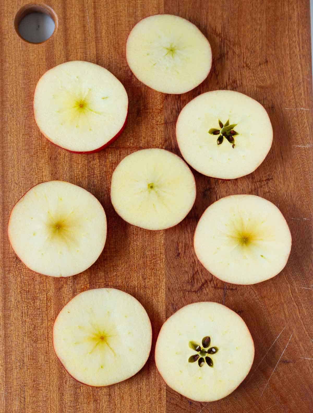 Sliced apples on a wooden board.