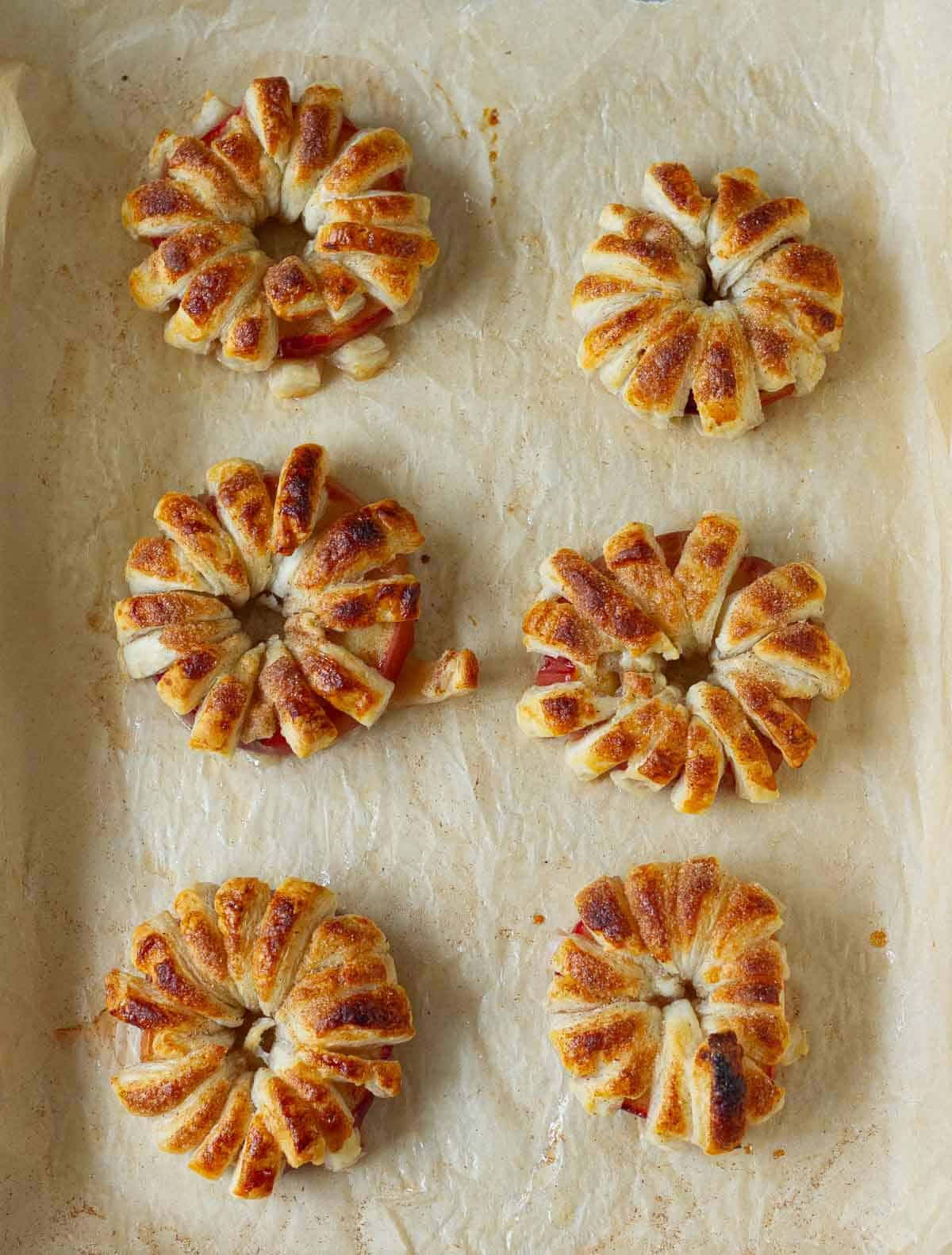 Baked apple rings on parchment paper.